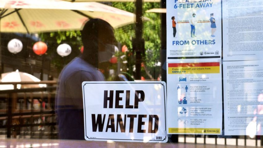 A 'Help Wanted' sign posted outside a restaurant.