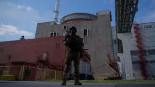 Un soldado ruso monta guardia frente a uno de los reactores de la planta nuclear de Zaporiyia, en Ucrania, el viernes.