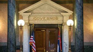 La bandera del estado de Mississippi (derecha) se ve afuera de la oficina del gobernador en el edificio del Capitolio del Estado de Mississippi en Jackson, Mississippi, el 28 de junio de 2020.