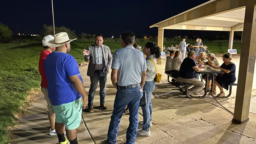 Rep. Gabe Vasquez, D-N.M., holds up a hand as he talks to guests at a “carne asada” campaign picknick, Tuesday, Aug. 20, 2024, in Chaparral, N.M., one of the region’s oldest unincorporated “colonias” communities where many migrant workers settled over the past century on cheap plots of land, often with limited access to water or electricity. Vasquez touts his knowledge of the border region as the U.S.-born son of immigrants while seeking reelection in a rematch against former Republican Congresswoman Yvette Herrell. (AP Photo/Morgan Lee)