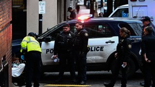 Oficiales de policía de Portland observan mientras los paramédicos de American Medical Response transportan a un paciente después de que le administraran un aerosol nasal de la marca Narcan, por una presunta sobredosis de fentanilo en Portland, Oregon, el 25 de enero de 2024.