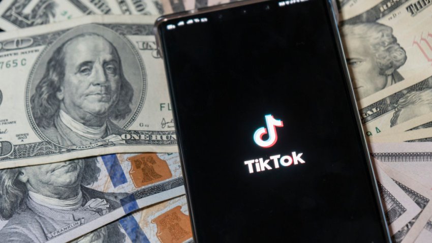 SHANGHAI, CHINA – AUGUST 04 2020: A staged view of TikTok and US dollar banknotes. (Photo credit should read WANG GANG / Feature China/Future Publishing via Getty Images)