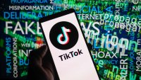 TikTok icon logo displayed on a smartphone with disinformation on screen seen in the background, in this photo illustration. On 15 October 2023, in Brussels, Belgium.
